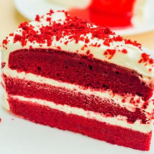 Uma foto do bolo Redvelvet todo vermelho e com recheio de creme